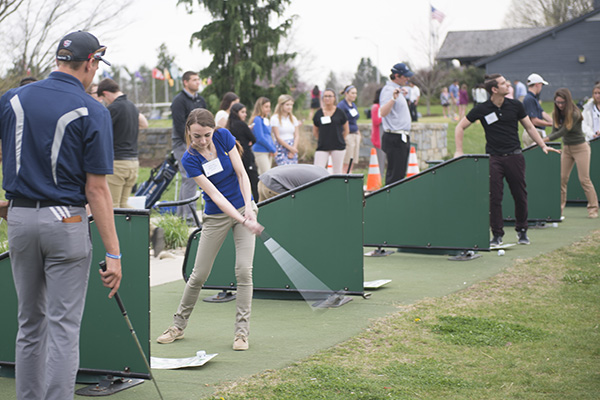 Students swings golf club during golf practice