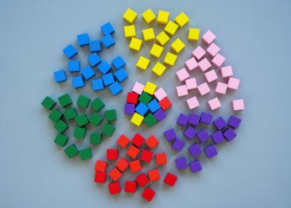 6 groups of cubes, each a pile of a single, distinct color, surround a multicolored pile that is made of up of cubes from each individual pile surrounding them. 