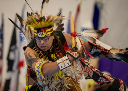 A dancer in traditional Native American clothing
