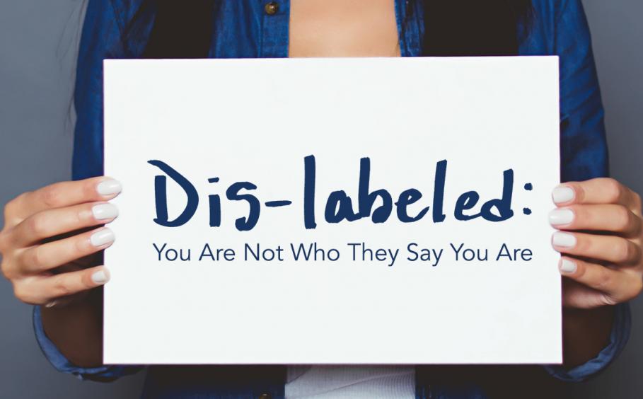 Woman holding a sign. Dis-labeled: You Are Not Who They Say You Are