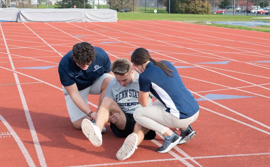 Trainers evaluating an injured athlete. 