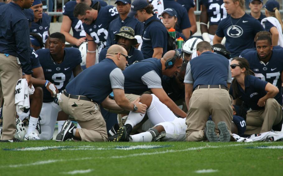 Athletic trainers on the football field working on a player.