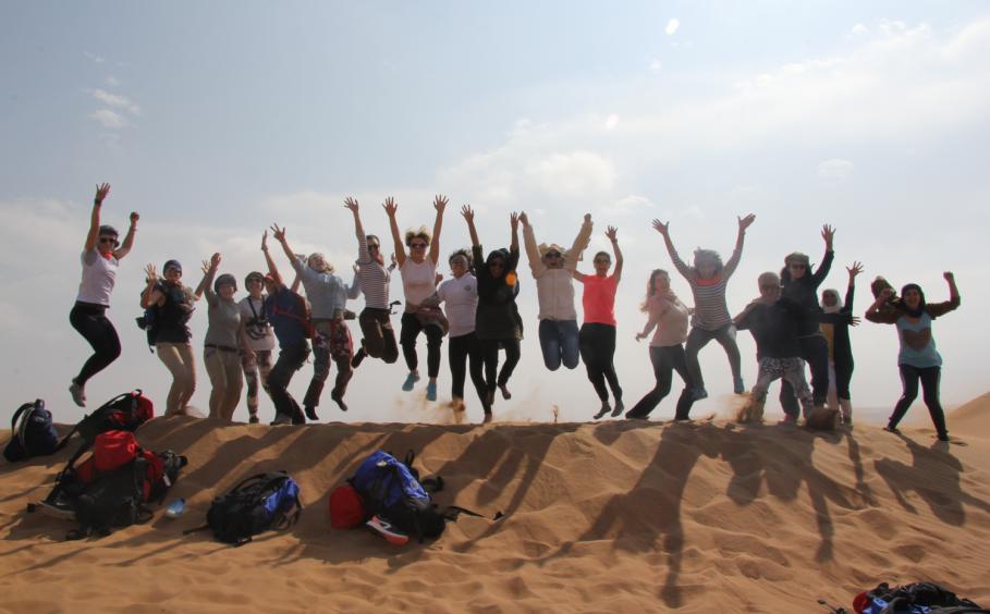 Group of people jumping on the desert