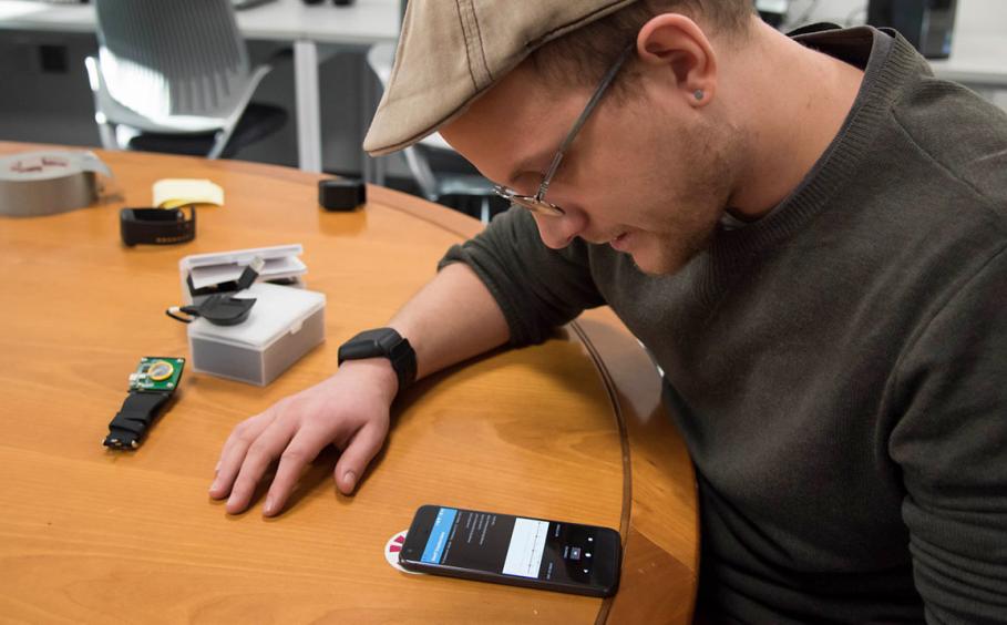 Graduate student working on pairing the watch device with a smart phone.