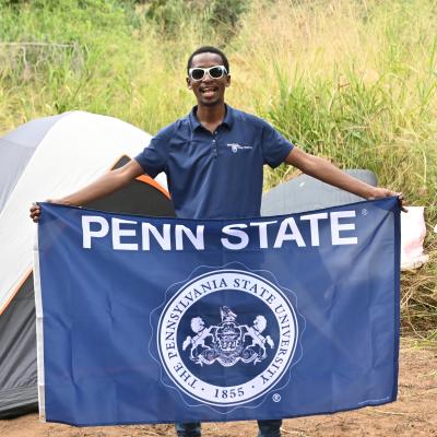 RPTM Student holding a Penn State flag in Tanzania