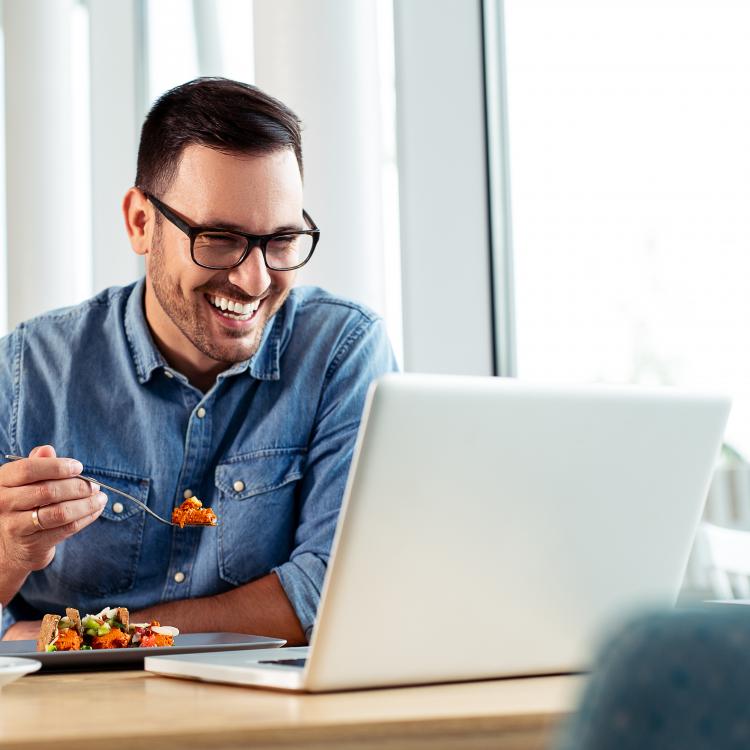 Man eating lunch at computer