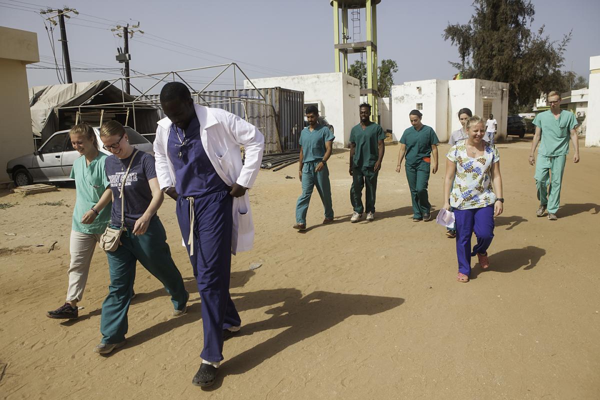 =Students walking with a doctor across a medical site